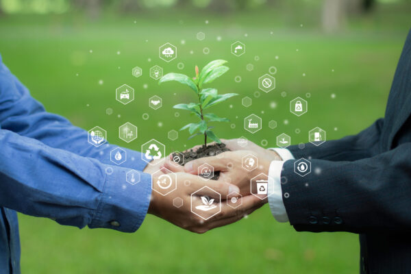 EUDR: O que é e como impacta as exportações brasileiras? pessoas segurando uma semente de árvore na mão com ícones de sustentabilidade do planeta